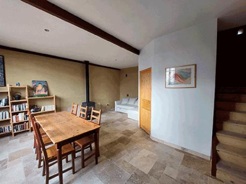a living room with a wooden table and chairs at Gîte Xin Dao in Sémézies-Cachan