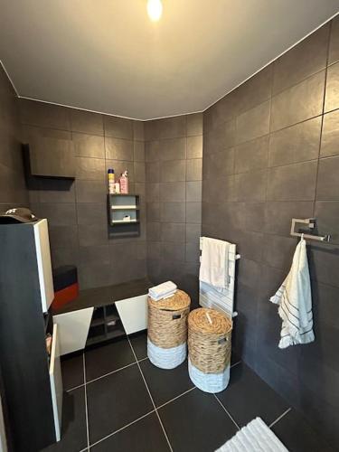 La salle de bains est pourvue de 2 paniers sur un mur carrelé. dans l'établissement Appartement T2 très bon standing !, à Ajaccio