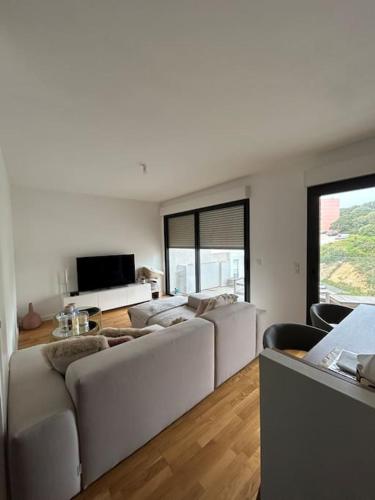 un salon avec des meubles blancs et une grande fenêtre dans l'établissement Appartement T2 très bon standing !, à Ajaccio