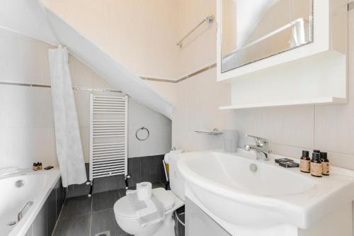 a white bathroom with a sink and a toilet at Delmare Delia maisonette in Yerakiní