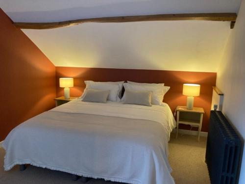 una camera da letto con un grande letto bianco con due lampade di Chambres & Table d'hôtes de La Vieille Ferme a Salon-la-Tour