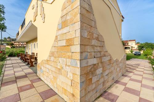 a wall made out of tiles on the side of a building at Kosmos Hotel St5 in Agios Stefanos in Agios Stefanos