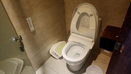 a bathroom with a toilet with the lid up at 車站100m民宿丨電梯附停車場 in Hualien City