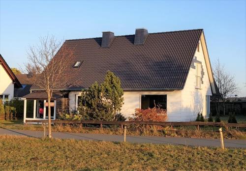 een wit huis met een zwart dak bij Ferienhaus Grenzweg in Winterberg