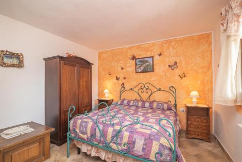 a bedroom with a bed and a wooden cabinet at Stazzu La Piredda in Arzachena