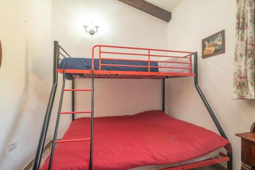 a bunk bed in a room with a red bed at Stazzu La Piredda in Arzachena