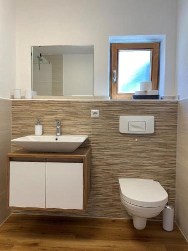 a bathroom with a sink and a toilet and a mirror at Ferienwohnung Zauberwald in Waldkirchen