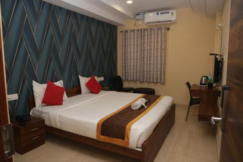 a bedroom with a large bed with red pillows at virat inn in Bangalore