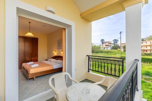 a bedroom with a bed and a balcony with a table and chairs at Kosmos Hotel St7 in Agios Stefanos in Agios Stefanos