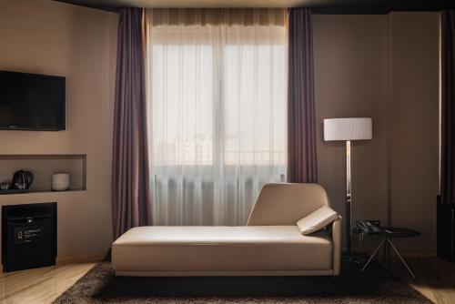 uma sala de estar com uma cadeira branca e uma janela em Hotel SB Ciutat Tarragona em Tarragona