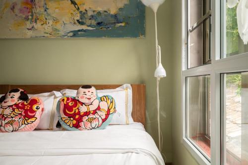 a bed with two clown pillows on it next to a window at Rong Hotel - Beijing Nanluoguxiang Branch in Beijing