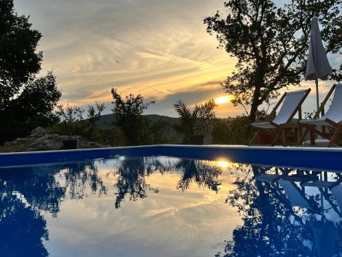 una piscina con puesta de sol en el fondo en Guesthouse P&A en Budva