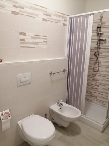 a white bathroom with a toilet and a sink at B&B da Giovanna Dimora del Turista in Santa Maria del Cedro
