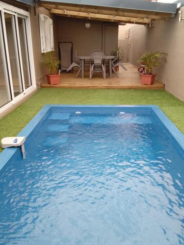 a large blue swimming pool in a yard with a table at Ti kaz Tata du sud Sauvage in Saint-Joseph