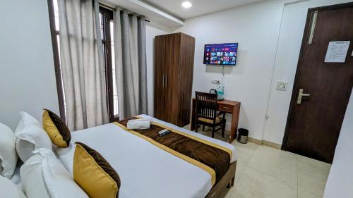 a hotel room with a bed and a desk in it at Hotel Prime Royalty Malviya Nagar in New Delhi