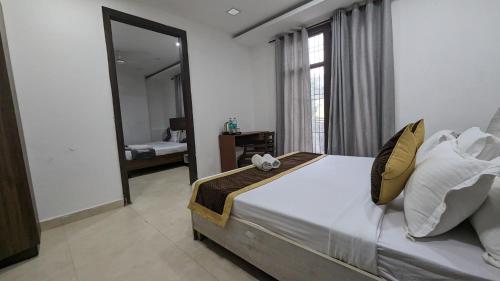 a bedroom with a large bed and a mirror at Hotel Prime Royalty Malviya Nagar in New Delhi