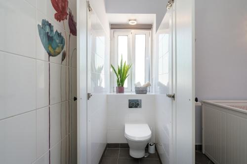 a white bathroom with a toilet and a window at Casa D'Nossa, casa tradicional e Moderna, vista 360º, piscina de agua salgada in Luz de Tavira