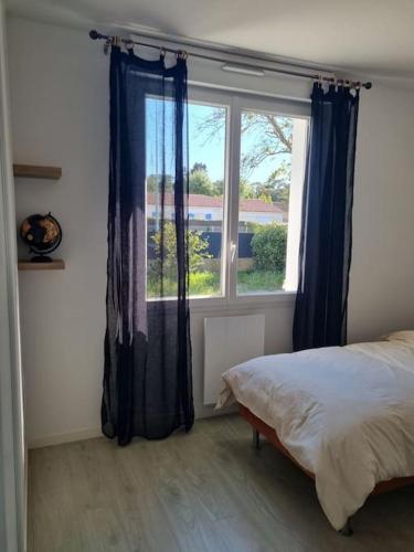 une chambre avec un lit et une grande fenêtre dans l'établissement Le Petit Rocher, à Saint-Jean-de-Monts