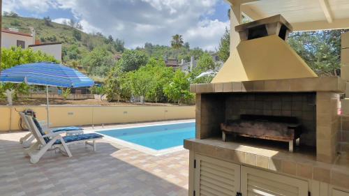 eine Terrasse mit einem Backofen im Freien und einem Pool in der Unterkunft Kakopetria's Holiday House in Kakopetria