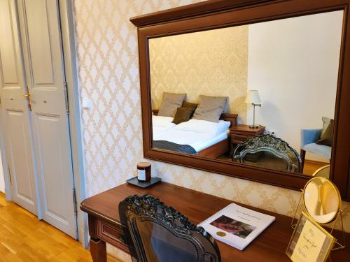 a bedroom with a bed and a large mirror at Városi Vendégház Szentendre in Szentendre