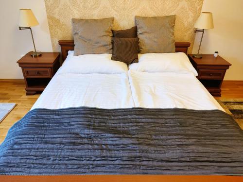 a large bed in a room with two night stands at Városi Vendégház Szentendre in Szentendre