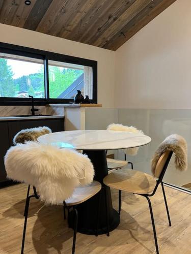 une pièce avec une table et des chaises avec des sièges en fourrure dans l'établissement Appartement cosy rénové, à Megève