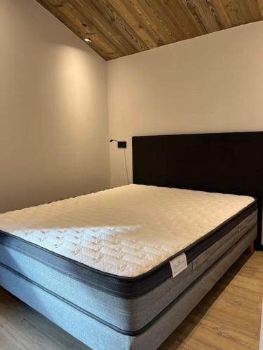 Ce lit se trouve dans un dortoir doté d'un matelas. dans l'établissement Appartement cosy rénové, à Megève