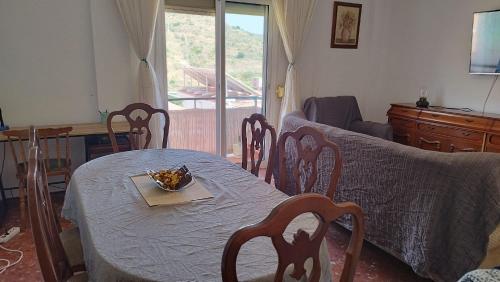 ein Wohnzimmer mit Tisch und Stühlen und einer Couch in der Unterkunft Apartamento Peñuelas Torrox in Torrox