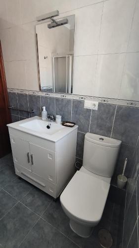 a bathroom with a toilet and a sink and a mirror at Apartamento Peñuelas Torrox in Torrox