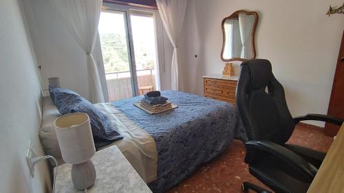 ein Schlafzimmer mit einem Bett und einem Stuhl und einem Fenster in der Unterkunft Apartamento Peñuelas Torrox in Torrox