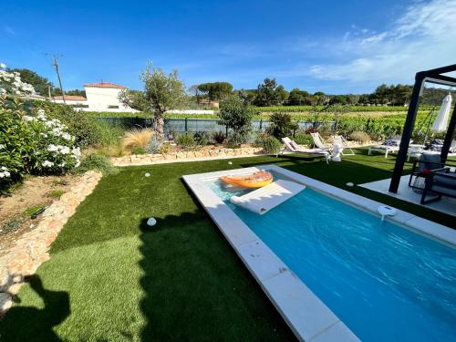 un patio con piscina y un patio con patio en jolie maison neuve au coeur des vignes en Cogolin