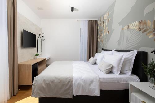 a bedroom with a bed with white sheets and pillows at Villa Estrella in Medulin for 10 people with sauna & whirpool just 6 m from the sea in Medulin