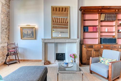 Una sala de estar con chimenea y una silla. en GuestReady - Canut Typique avec vue sur Lyon, en Fourvière