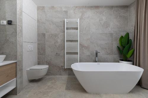 a bathroom with a white bath tub and a toilet at Villa Estrella in Medulin for 10 people with sauna & whirpool just 6 m from the sea in Medulin
