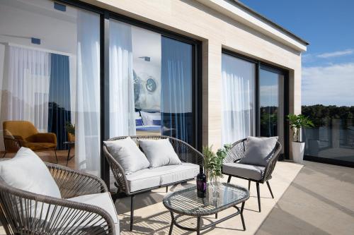 a balcony with chairs and a couch and a table at Villa Estrella in Medulin for 10 people with sauna & whirpool just 6 m from the sea in Medulin