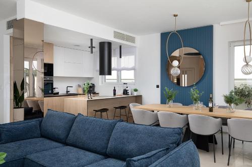 a living room with a blue couch and a kitchen at Villa Estrella in Medulin for 10 people with sauna & whirpool just 6 m from the sea in Medulin