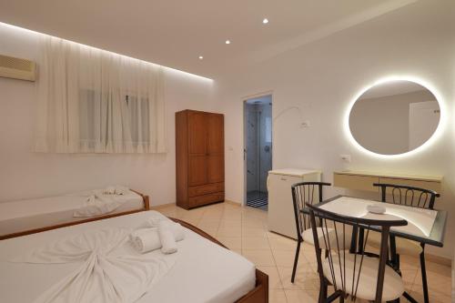 a bedroom with a bed and a table and a kitchen at Vila Melisa in Ksamil