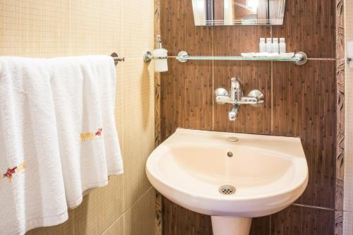 uma casa de banho com um lavatório branco e toalhas em Hotel Buena Vissta em Primorsko