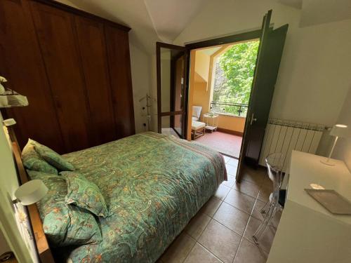 a bedroom with a bed and a door to a balcony at Sole e Lago in Stresa
