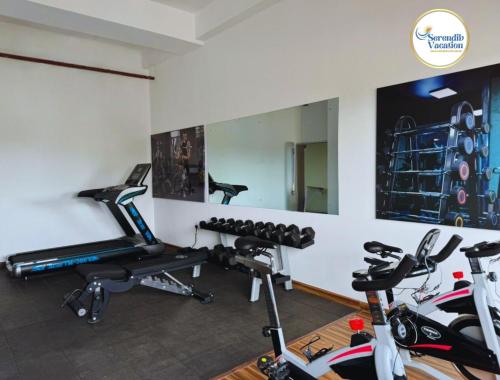 - une salle de sport avec 2 vélos d'exercice et un miroir dans l'établissement Negombo Ocean Breeze Luxury Studio by Serendib Vacation, à Negombo