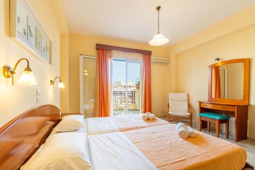 a bedroom with a large bed and a mirror at Kosmos Hotel St5 in Agios Stefanos in Agios Stefanos