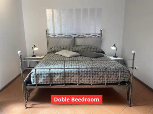 a bed with a metal frame and two lamps on tables at Appartamento a 50m da Piazza Alfieri in Asti