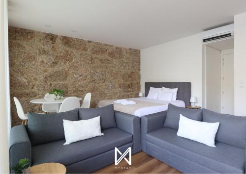 a bedroom with a bed and two couches at MyStay - D Maria Apartments in Vila Nova de Famalicão