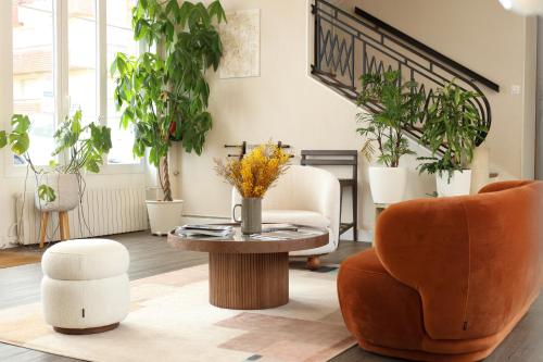 - un salon avec des plantes, une table et des chaises dans l'établissement Le Clos Normand, à Saint-Aubin-sur-Mer