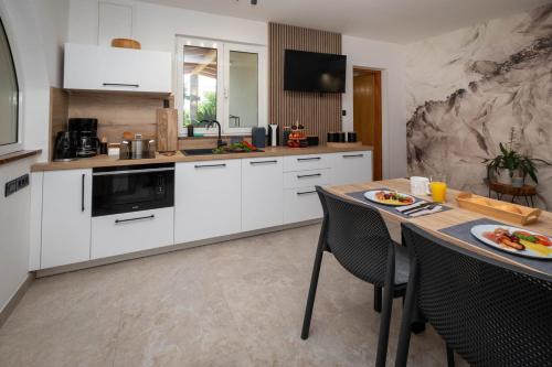 a kitchen with white cabinets and a table with food on it at Villa Kosta in Krk