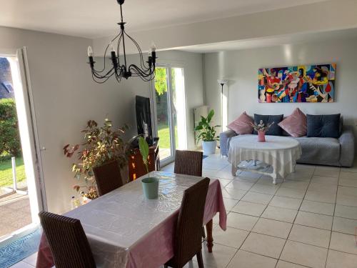 ein Wohnzimmer mit einem Tisch und einem Sofa in der Unterkunft Maison non fumeur - jardin 5 personnes aux portes de Brest in Guipavas
