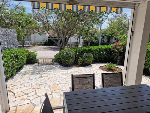 a patio with a table and chairs and a courtyard at Cozy apartment near beach in Gajac in Skunca