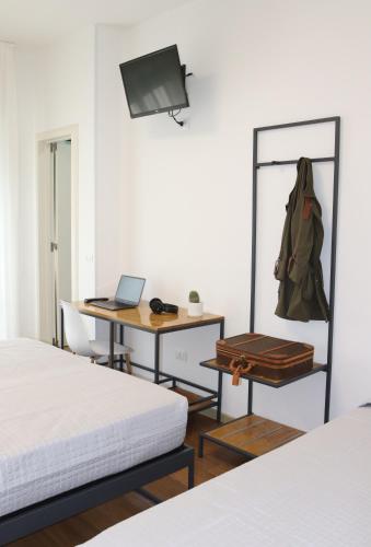 a room with two beds and a desk and a mirror at Villa Serena in Lido di Jesolo