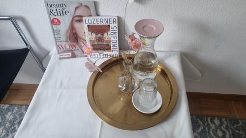 uma mesa com uma revista e um vaso de vidro com flores em Familien Haus em Lucerna
