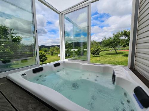 una vasca da bagno in una stanza con una grande finestra di Quinta Lama de Cima a Fafe